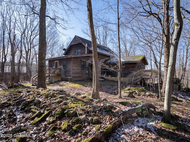 view of side of property with stairway and a wooden deck