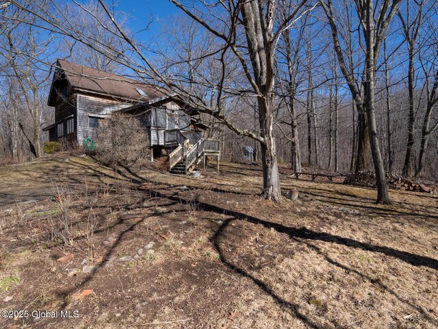 view of yard with a deck and stairs