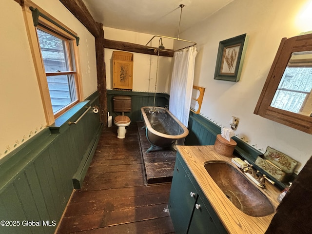 full bath featuring vanity, wood-type flooring, a bathtub, wainscoting, and a shower with shower curtain