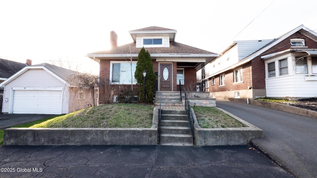 34 Lark St, Cohoes, NY 12047 - view of front of house with brick siding, a garage, a front yard, and roof with shingles