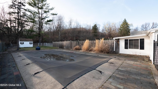 view of pool with a fenced in pool, an outdoor structure, a fenced backyard, a shed, and a patio
