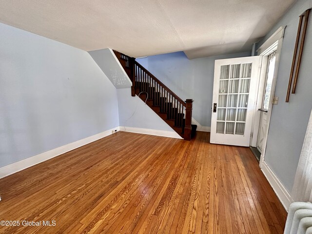 11 Middlesex Rd, East Greenbush, NY 12061 - interior space featuring stairway, baseboards, radiator heating unit, hardwood / wood-style flooring, and a textured ceiling