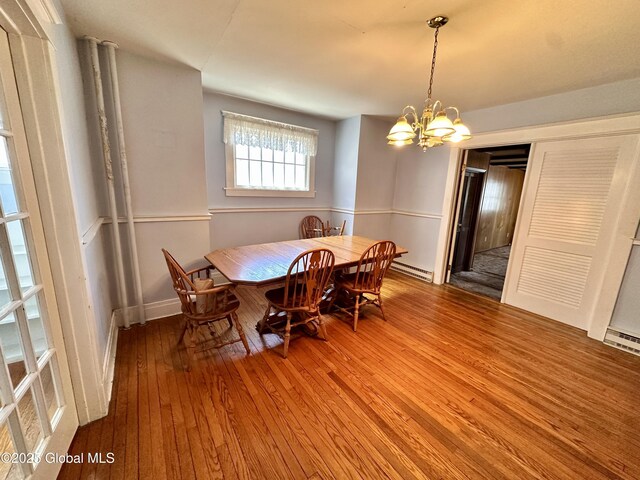 11 Middlesex Rd, East Greenbush, NY 12061 - dining area with a baseboard heating unit, baseboard heating, a chandelier, and hardwood / wood-style flooring