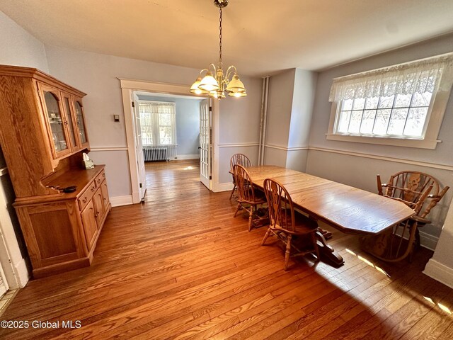 11 Middlesex Rd, East Greenbush, NY 12061 - dining area featuring a chandelier, baseboards, wood finished floors, and radiator heating unit