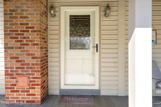 entrance to property featuring brick siding