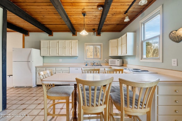 kitchen featuring white appliances, wooden ceiling, beam ceiling, plenty of natural light, and light countertops