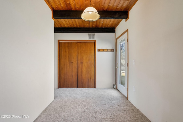 corridor featuring carpet, wooden ceiling, and beamed ceiling