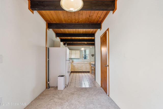 hall with beam ceiling, wood ceiling, light colored carpet, and light tile patterned floors