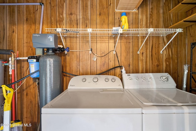 washroom with separate washer and dryer and wood walls