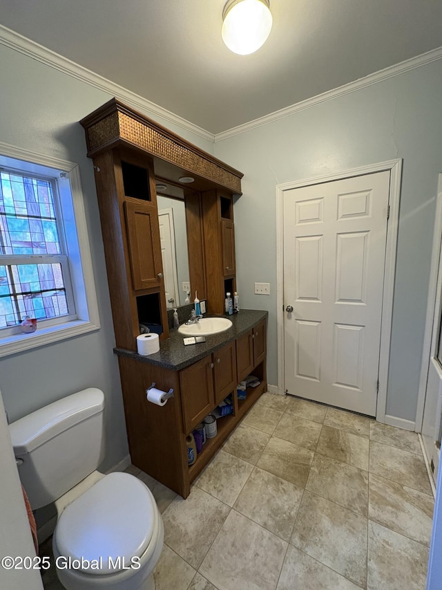 bathroom with vanity, baseboards, ornamental molding, and toilet
