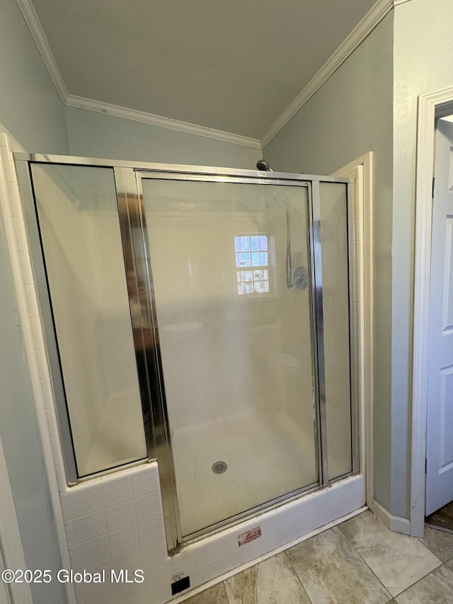 bathroom with baseboards, crown molding, and a stall shower