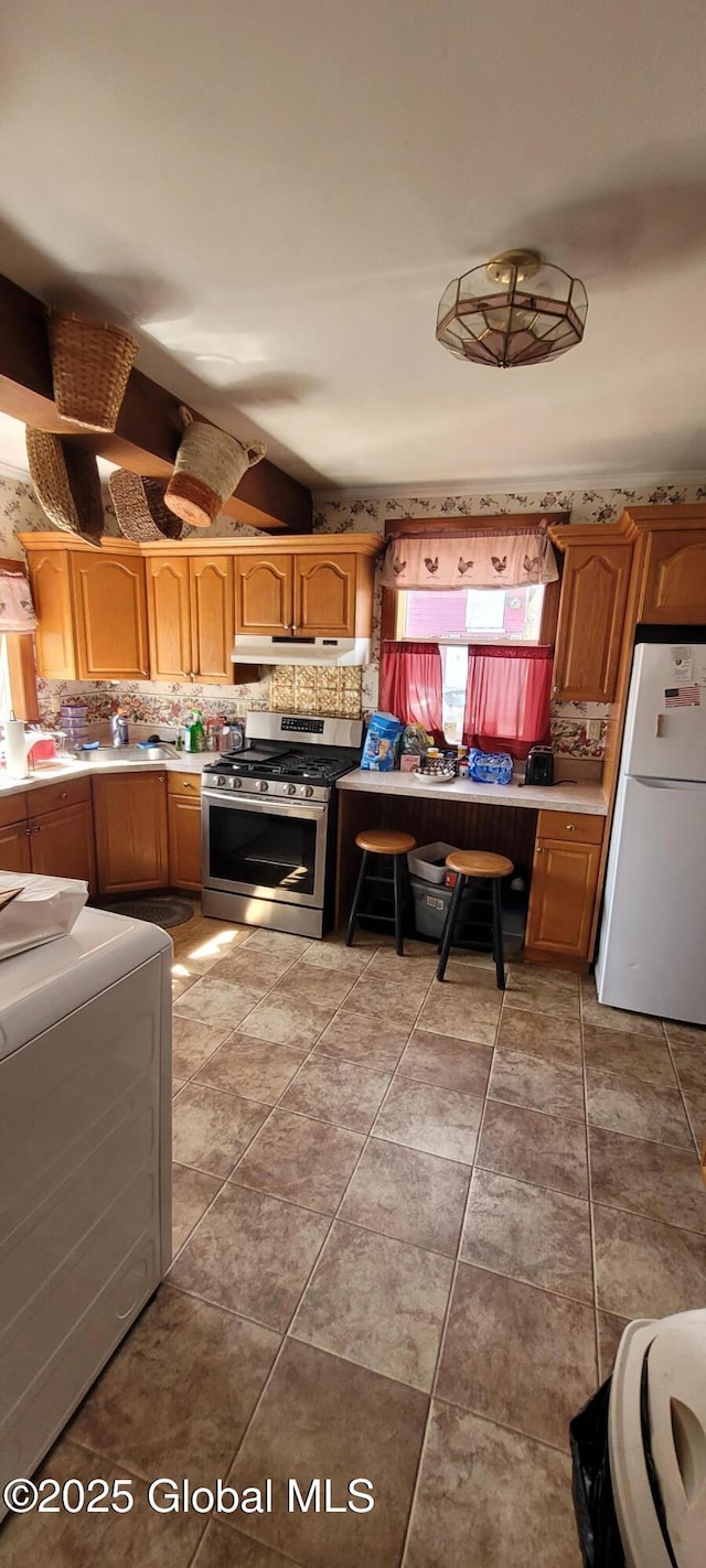 755 County Route 7, Schodack, NY 12063 - kitchen featuring freestanding refrigerator, light countertops, under cabinet range hood, stainless steel gas range oven, and tasteful backsplash