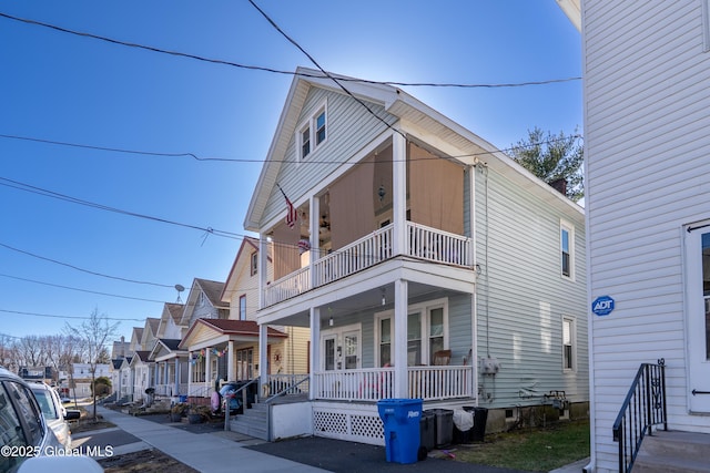 view of front facade with a residential view, a balcony, and covered porch