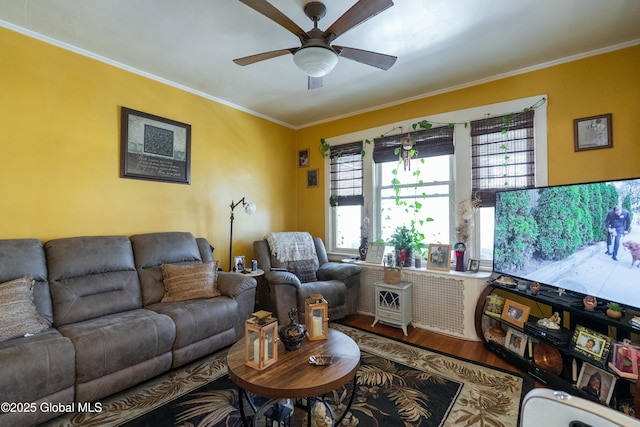 living room featuring crown molding, a ceiling fan, and wood finished floors