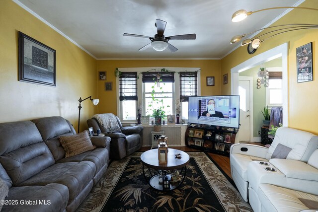 living area with wood finished floors, a ceiling fan, and ornamental molding