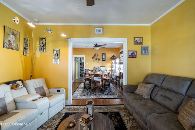 living room featuring crown molding, a ceiling fan, and wood finished floors