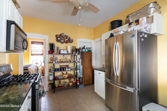 kitchen featuring stainless steel appliances, dark countertops, ceiling fan, and white cabinets