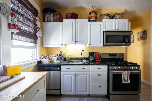 kitchen with white cabinets, appliances with stainless steel finishes, and a sink