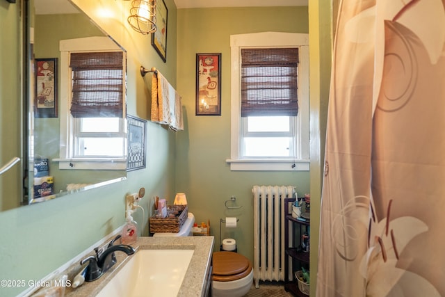 bathroom featuring a shower with shower curtain, radiator, vanity, and toilet