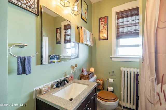 bathroom with vanity, toilet, and radiator