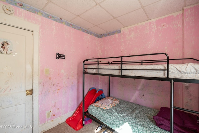 bedroom featuring a drop ceiling and carpet floors