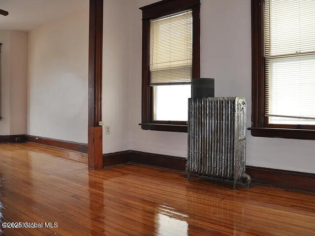 698 State St, Albany, NY 12203 - spare room with baseboards, wood-type flooring, and radiator