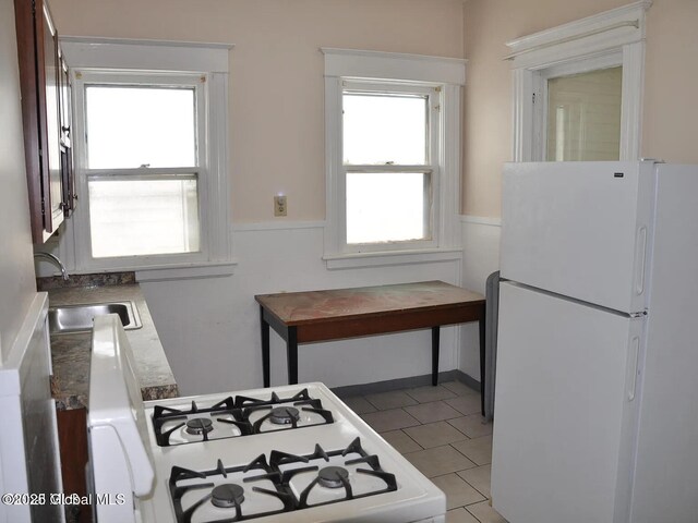 698 State St, Albany, NY 12203 - kitchen featuring a sink, white appliances, wainscoting, and light tile patterned floors