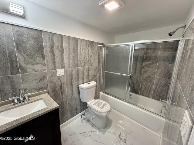 9 Brandt Pl, Amsterdam, NY 12010 - bathroom with vanity, marble finish floor, tile walls, toilet, and combined bath / shower with glass door
