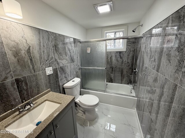 9 Brandt Pl, Amsterdam, NY 12010 - full bathroom with toilet, marble finish floor, combined bath / shower with glass door, tile walls, and vanity