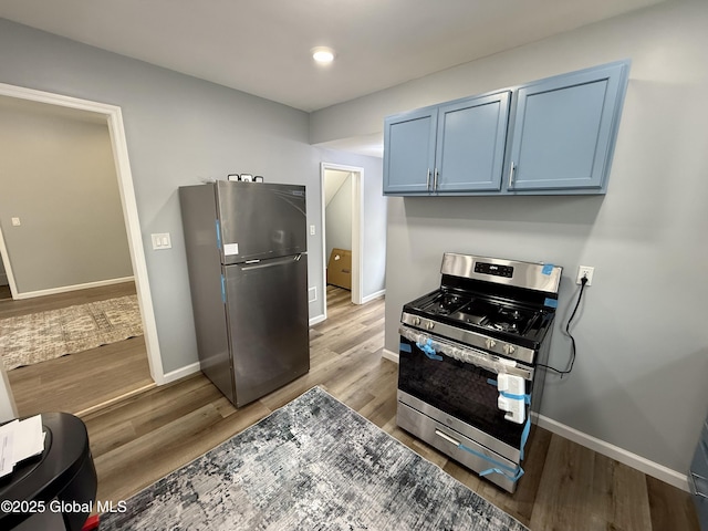 9 Brandt Pl, Amsterdam, NY 12010 - kitchen with blue cabinetry, stainless steel appliances, baseboards, and wood finished floors