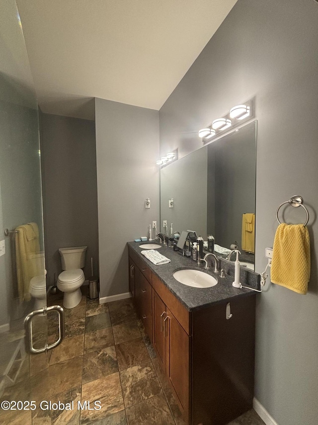 bathroom featuring double vanity, baseboards, and a sink