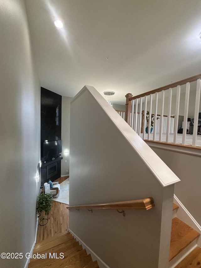 stairway with wood finished floors and baseboards