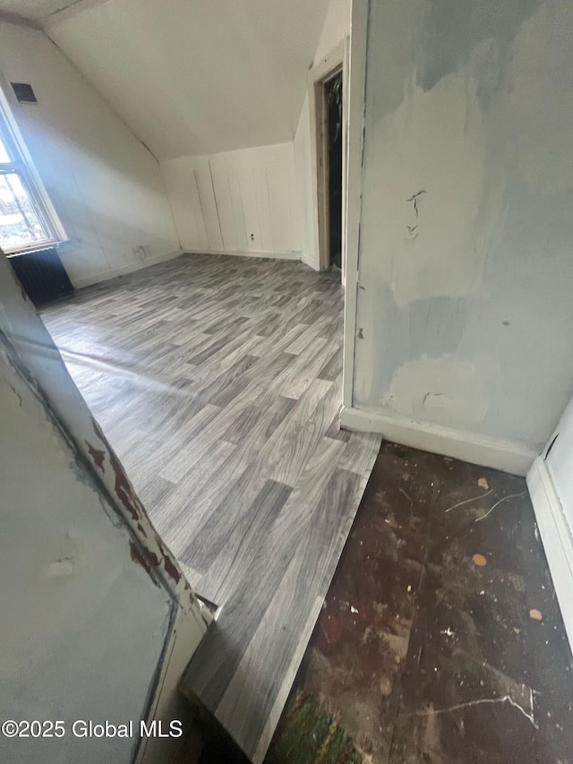 additional living space with vaulted ceiling and wood finished floors