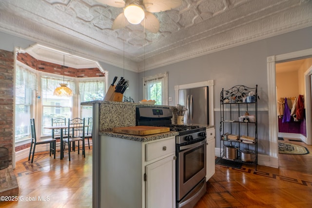 14 Pleasant St, Ballston Spa, NY 12020 - kitchen with appliances with stainless steel finishes, white cabinetry, a ceiling fan, baseboards, and brick wall