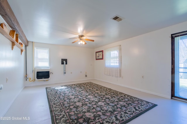 living area with baseboards, heating unit, visible vents, and ceiling fan