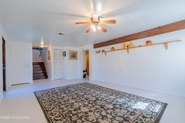 unfurnished room with visible vents, stairway, and a ceiling fan