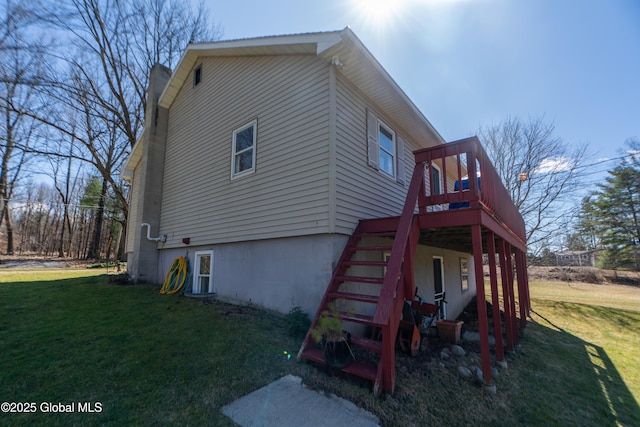view of side of property featuring a deck, a yard, and stairs