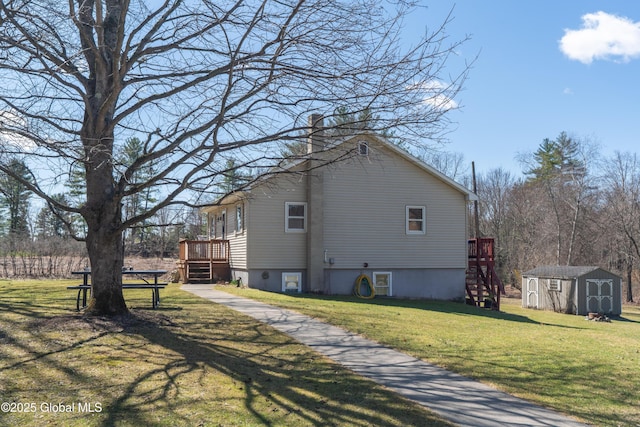 view of side of home with an outdoor structure, a wooden deck, a storage unit, and a lawn