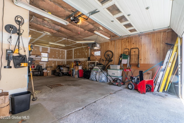 garage featuring a garage door opener and wooden walls