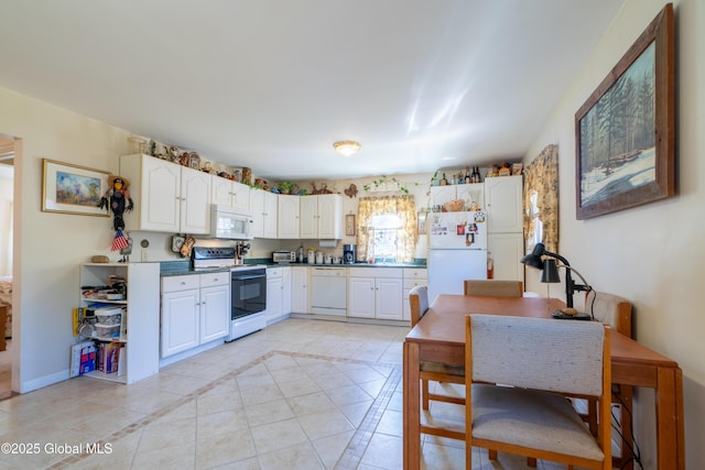 kitchen featuring white cabinetry, light tile patterned flooring, baseboards, and white appliances