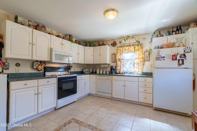 kitchen with white appliances, light tile patterned floors, a sink, dark countertops, and white cabinets