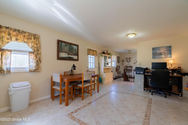 interior space with baseboards, a ceiling fan, and light tile patterned floors