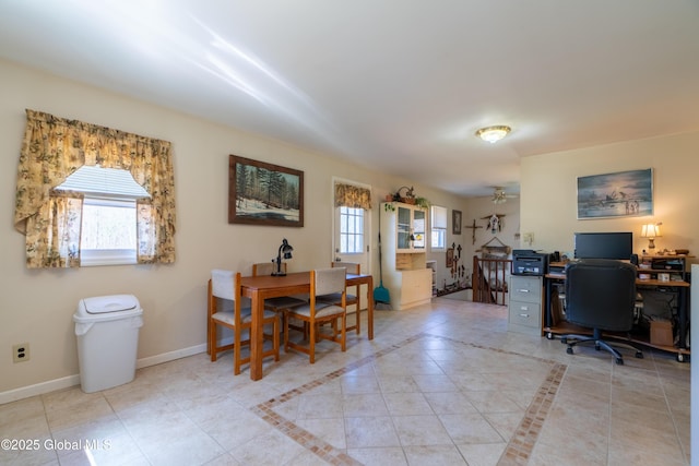 office space with baseboards, a ceiling fan, light tile patterned floors, and plenty of natural light