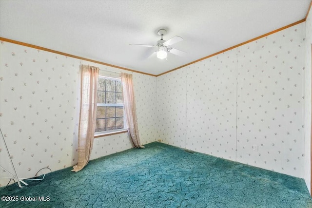 carpeted empty room featuring a ceiling fan, wallpapered walls, and ornamental molding