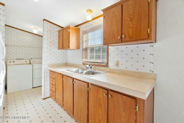 kitchen with washer and clothes dryer, light countertops, a sink, light floors, and brown cabinets