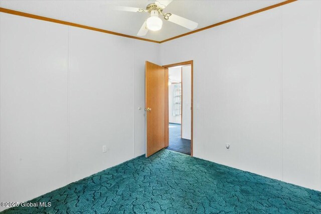 empty room featuring carpet flooring, ornamental molding, and a ceiling fan