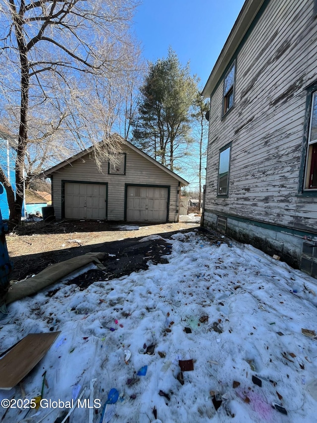 snow covered garage featuring a detached garage
