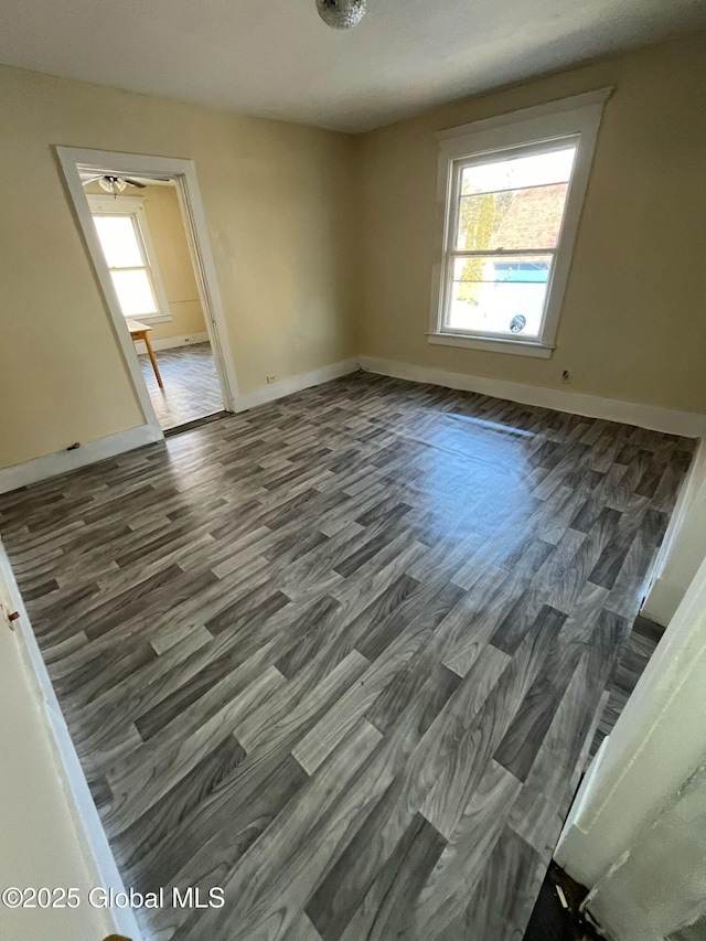 unfurnished room with baseboards and wood finished floors