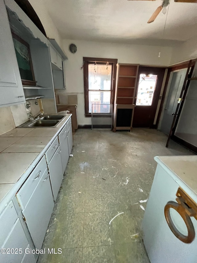 kitchen with light countertops, a sink, and a ceiling fan
