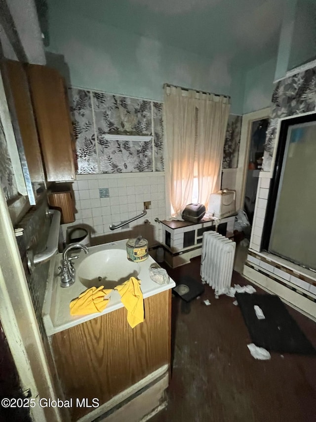 bathroom featuring a bathing tub, wood finished floors, radiator heating unit, a shower with shower door, and decorative backsplash